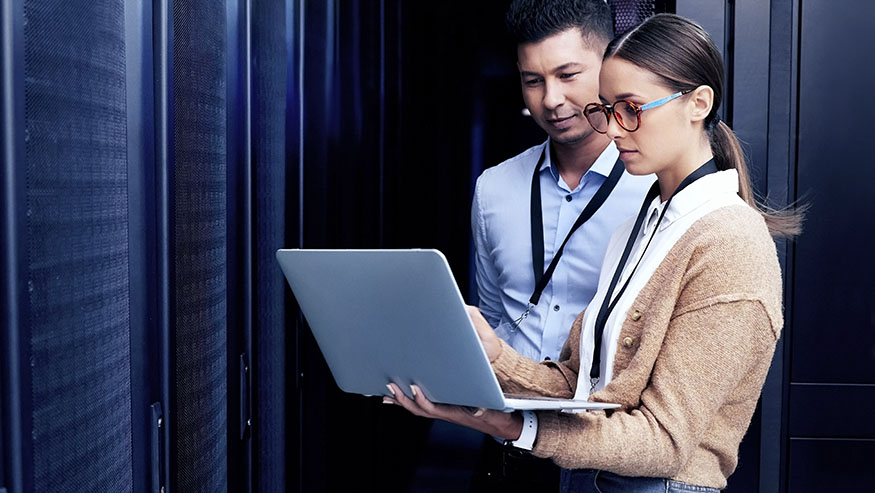 Two people looking at a laptop indoors